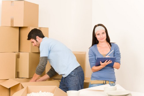 Professional movers carrying items from a Shoreditch flat with stairs